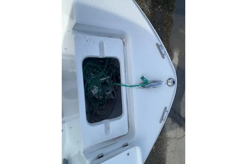 Slide: The Image of 2021 Release 210 RX boat bow with open storage compartment and rope. - 18