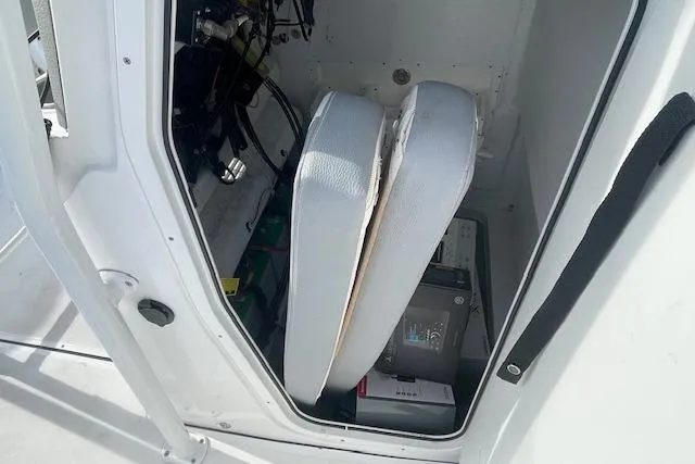 Slide: The Image of Storage compartment in a 2021 Release 210 RX boat, featuring cushions and equipment. - 23