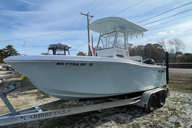 Slide: The Image of 2021 Release 210 RX boat on trailer, parked outdoors under clear sky. - 4
