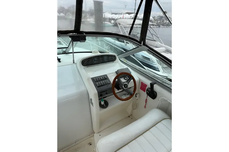 Slide: The Image of 1996 Sea Ray 270 Sundancer boat cockpit with steering wheel and control panel. - 10