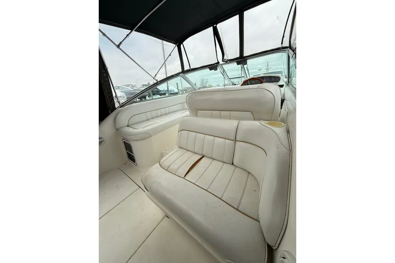 Slide: The Image of 1996 Sea Ray 270 Sundancer interior with white leather seating and dashboard view. - 11