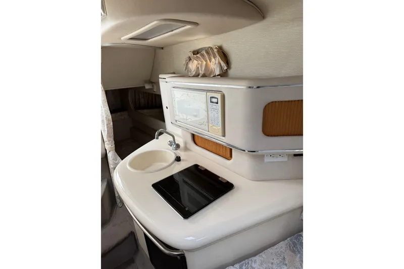 Slide: The Image of 1996 Sea Ray 270 Sundancer cabin interior with kitchenette, sink, and microwave. - 15