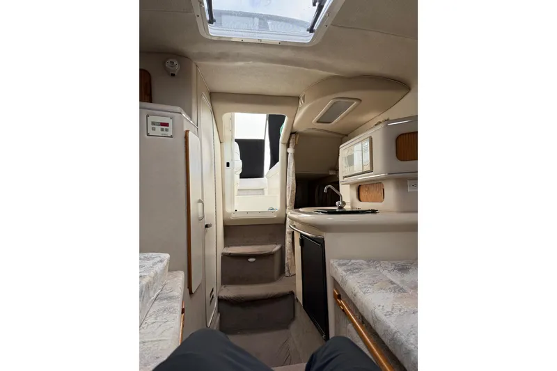 Slide: The Image of Interior of 1996 Sea Ray 270 Sundancer boat, featuring compact kitchen and seating area. - 17