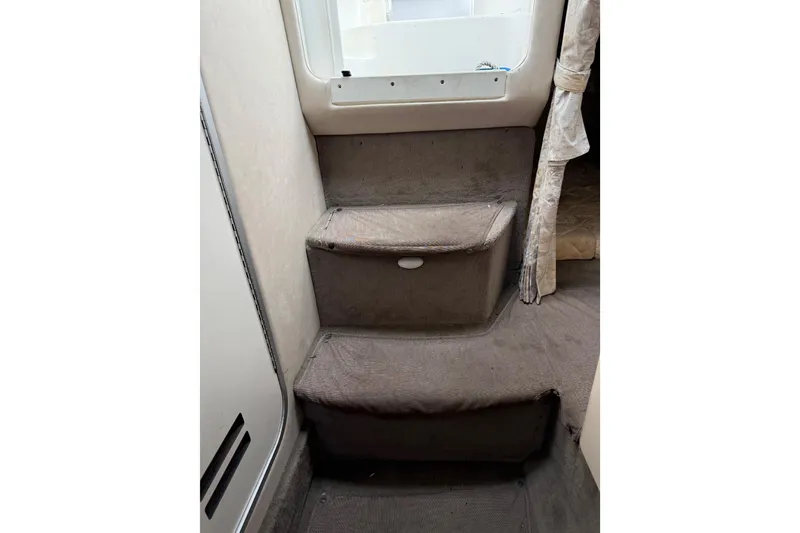 Slide: The Image of Interior stairs of 1996 Sea Ray 270 Sundancer boat, featuring carpeted steps and a window. - 20