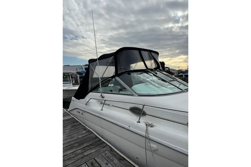 Slide: The Image of 1996 Sea Ray 270 Sundancer boat docked under cloudy sky. - 5