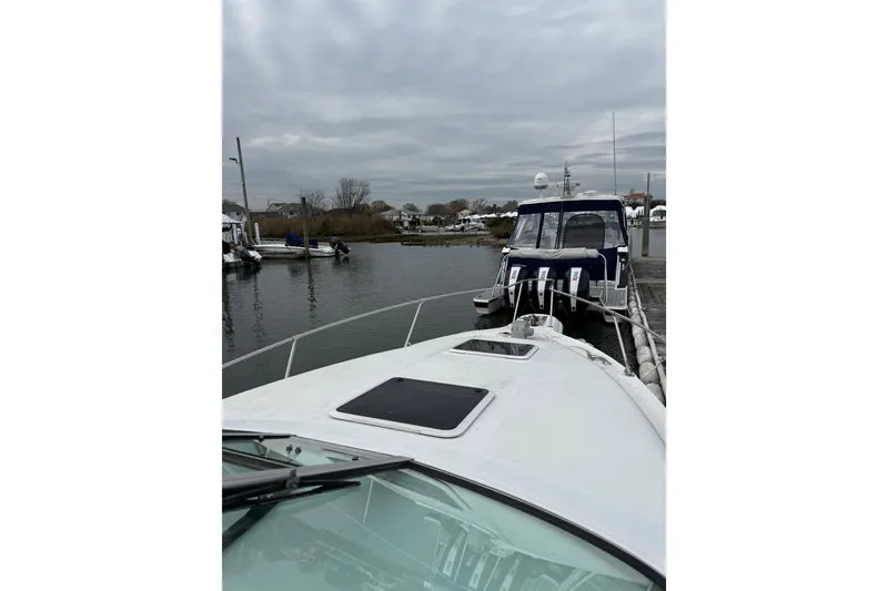 Slide: The Image of 1996 Sea Ray 270 Sundancer docked in a marina under cloudy skies. - 8