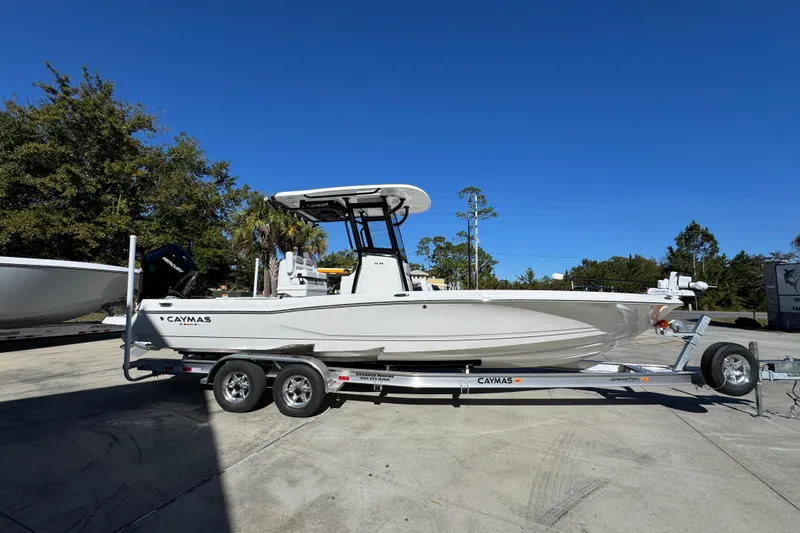 Slide: The Image of 2026 Caymas 28 HB boat on trailer, parked outdoors under clear blue sky. - 10