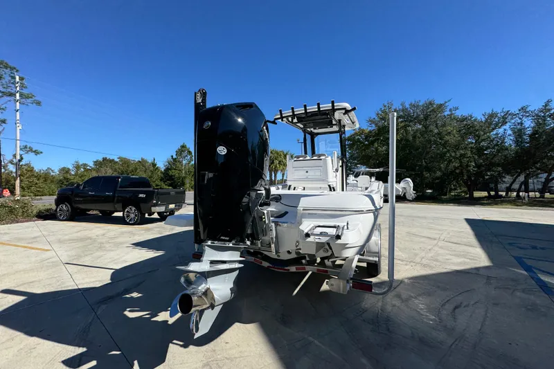 Slide: The Image of 2026 Caymas 28 HB boat with powerful outboard motor, parked outdoors under clear blue sky. - 14