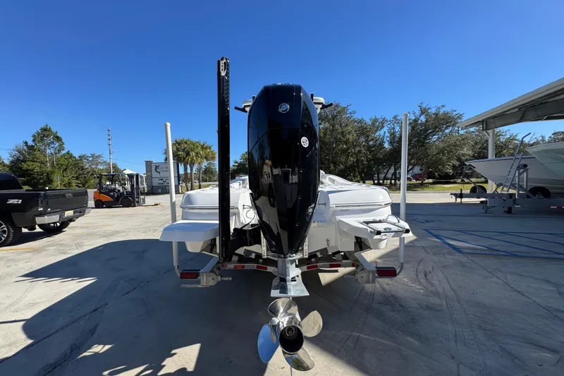 Slide: The Image of 2026 Caymas 28 HB boat with powerful outboard motor in a sunny marina setting. - 15