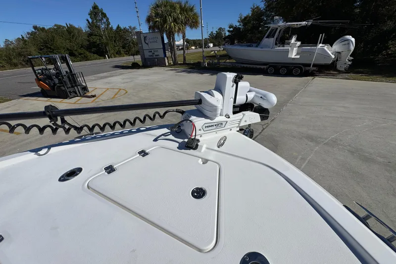 Slide: The Image of 2026 Caymas 28 HB boat with Minn Kota trolling motor on deck, parked outdoors. - 21