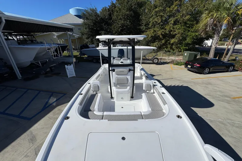 Slide: The Image of 2026 Caymas 28 HB boat displayed outdoors, showcasing spacious deck and seating. - 23