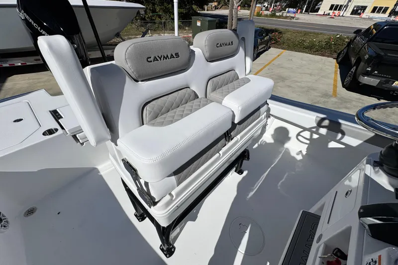Slide: The Image of 2026 Caymas 28 HB boat with cushioned seating and steering wheel in a parking lot. - 34