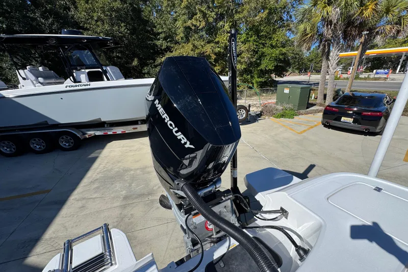 Slide: The Image of 2026 Caymas 28 HB boat with Mercury engine, parked near a trailer and car. - 39