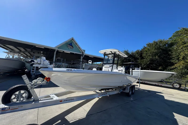 Slide: The Image of 2026 Caymas 28 HB boat on trailer, parked outdoors under clear blue sky. - 4