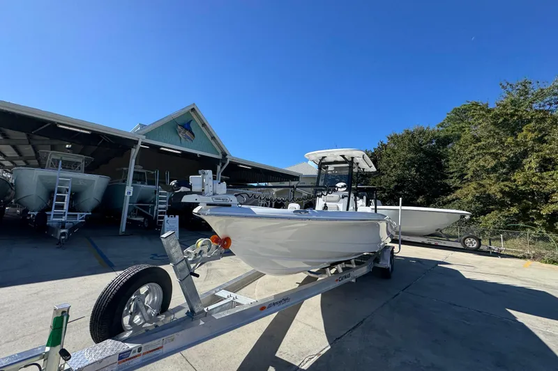 Slide: The Image of 2026 Caymas 28 HB boat on trailer outside a marina under clear blue sky. - 5