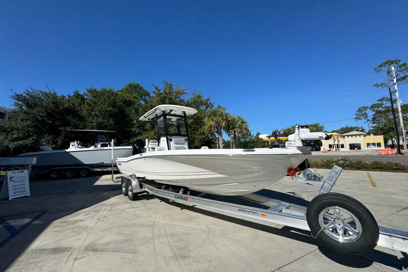 Slide: The Image of 2026 Caymas 28 HB boat on trailer, parked outdoors under clear blue sky. - 8