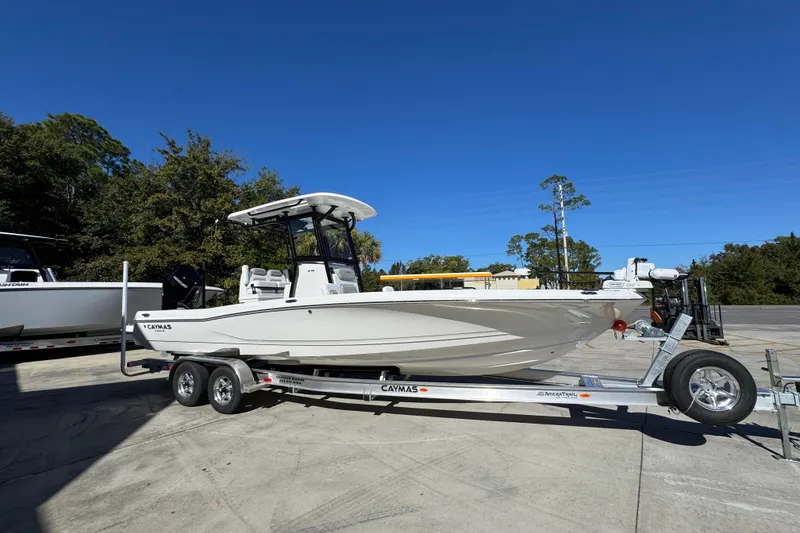 Slide: The Image of 2026 Caymas 28 HB boat on trailer, parked outdoors under clear blue sky. - 9