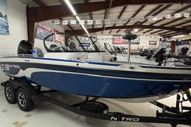 Slide: The Image of 2026 Nitro ZV19 Pro boat in showroom, blue and white design, on trailer. - 7