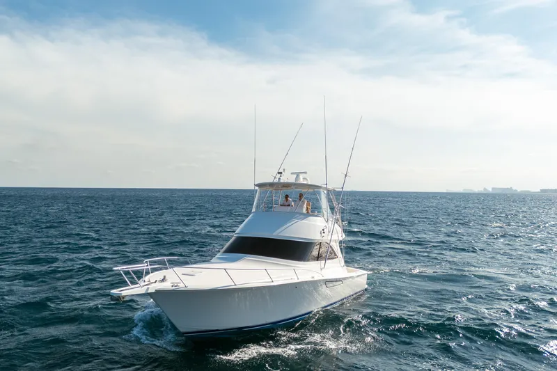 Slide: The Image of 2008 Viking 42 Convertible yacht cruising on open sea under clear sky. - 13