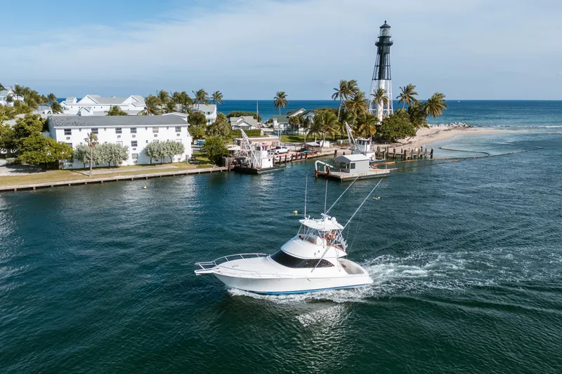 Slide: The Image of 2008 Viking 42 Convertible yacht cruising near lighthouse and palm trees. - 19