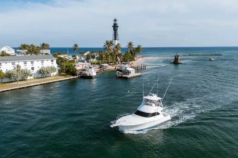 Slide: The Image of 2008 Viking 42 Convertible yacht cruising near a coastal lighthouse and palm trees. - 20
