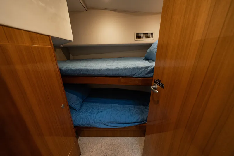 Slide: The Image of 2008 Viking 42 Convertible yacht cabin with wooden interior and bunk beds. - 23