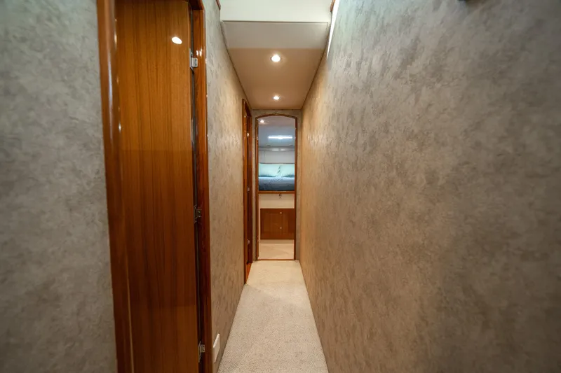 Slide: The Image of Hallway inside 2008 Viking 42 Convertible yacht, featuring wooden doors and soft lighting. - 24