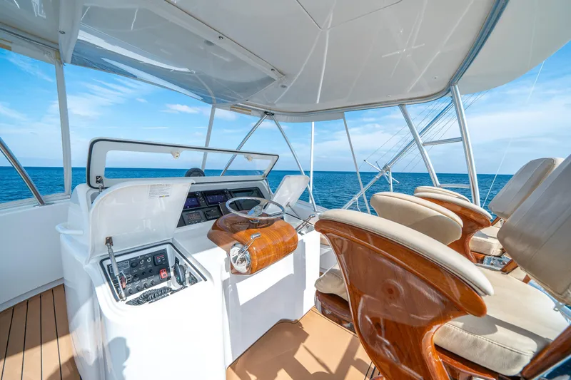 Slide: The Image of 2008 Viking 42 Convertible yacht helm with ocean view, featuring luxurious seating and navigation controls. - 47