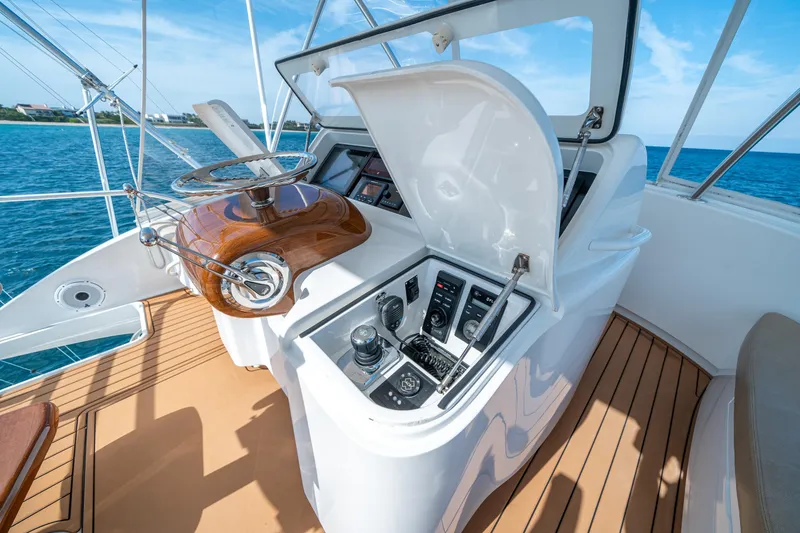 Slide: The Image of 2008 Viking 42 Convertible yacht helm with wooden steering wheel and control panel. - 49