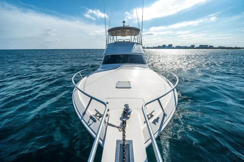 Slide: The Image of 2008 Viking 42 Convertible yacht cruising on open sea under clear sky. - 59