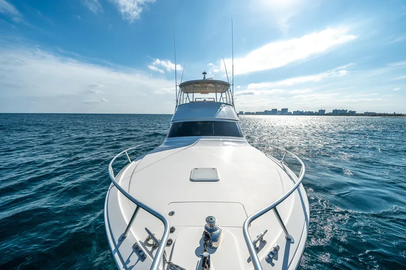 Slide: The Image of 2008 Viking 42 Convertible yacht cruising on open sea under clear blue sky. - 60