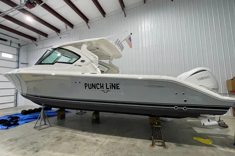 The Image of 2024 Pursuit DC 326 Dual Console boat in a garage, side view. - 0