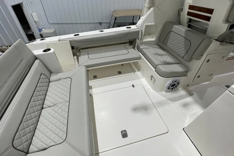 Slide: The Image of 2024 Pursuit DC 326 Dual Console interior with elegant seating and wooden table. - 21