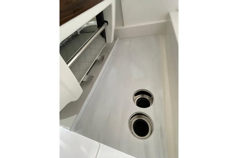 Slide: The Image of 2024 Pursuit DC 326 Dual Console interior detail with storage and cup holders. - 26