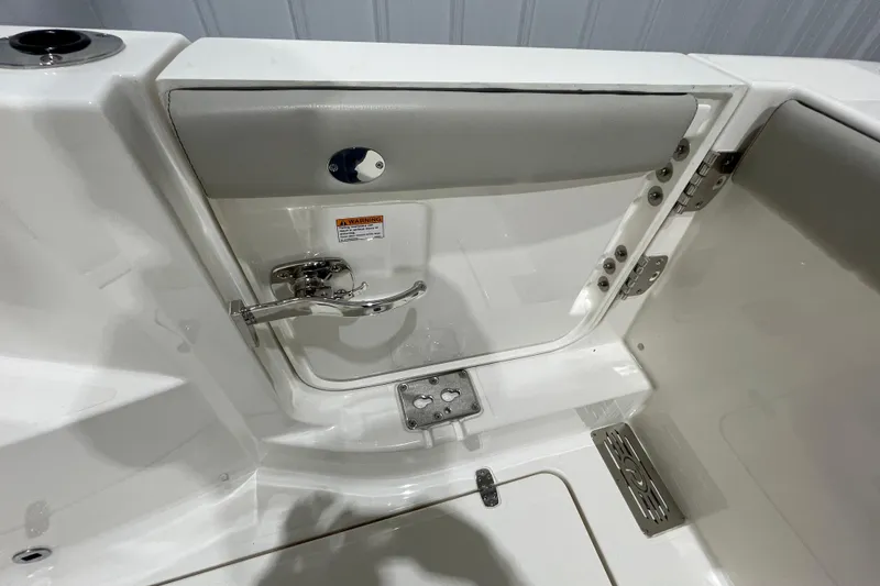 Slide: The Image of 2024 Pursuit DC 326 Dual Console boat interior with stainless steel fixtures and storage compartment. - 28