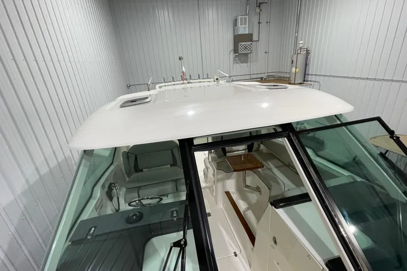 Slide: The Image of 2024 Pursuit DC 326 Dual Console boat in indoor storage, showcasing sleek design and spacious interior. - 36