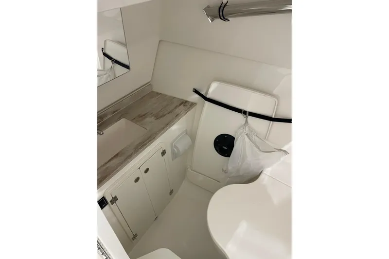 Slide: The Image of 2024 Pursuit DC 326 Dual Console boat interior with sink and storage cabinets. - 38