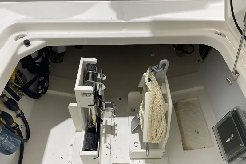 Slide: The Image of 2024 Pursuit DC 326 Dual Console storage compartment with rope and equipment. - 39