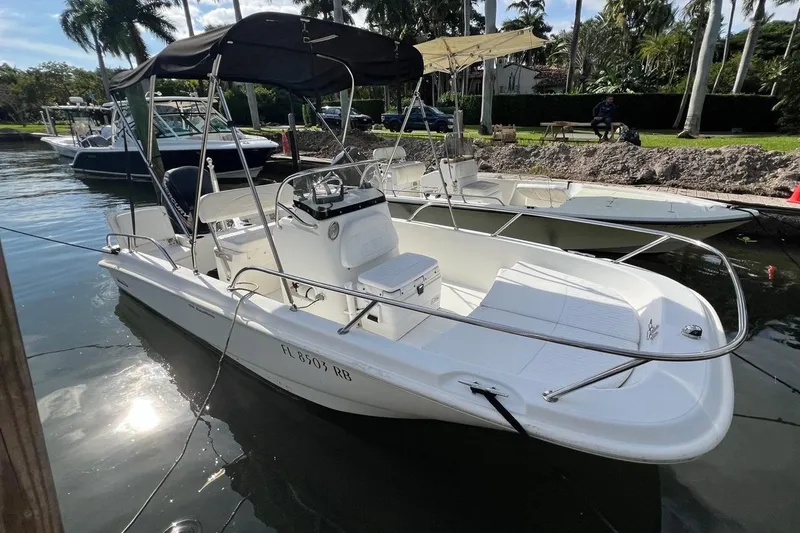The Image of 2016 Boston Whaler 170 Dauntless boat docked in a sunny marina setting. - 0