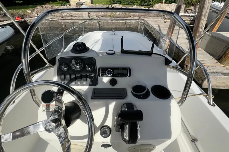 Slide: The Image of 2016 Boston Whaler 170 Dauntless boat console with steering wheel and controls. - 10