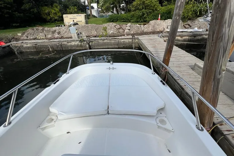 Slide: The Image of 2016 Boston Whaler 170 Dauntless boat docked, featuring a spacious bow area. - 12