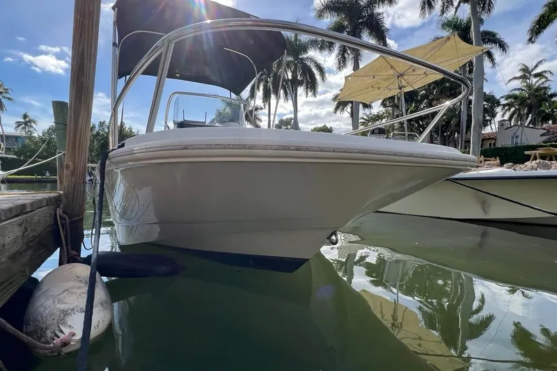 Slide: The Image of 2016 Boston Whaler 170 Dauntless docked, surrounded by palm trees and calm water. - 5