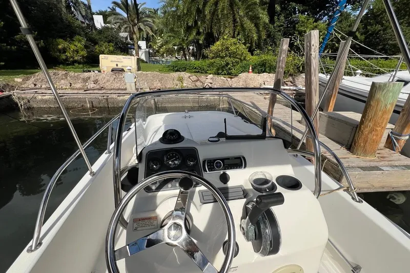 Slide: The Image of 2016 Boston Whaler 170 Dauntless boat cockpit with steering wheel and control panel. - 6