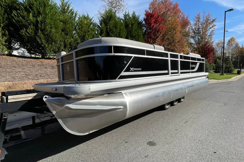 The Image of 2026 Godfrey Xperience 2286 SBX Sport Tube pontoon boat on trailer, parked on street. - 0