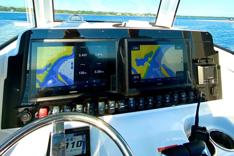 Slide: The Image of 2021 Sea Hunt Ultra 265 SE dashboard with dual Garmin navigation screens on open water. - 13