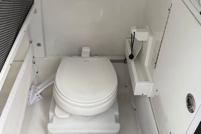 Slide: The Image of 2021 Sea Hunt Ultra 265 SE boat interior with compact marine toilet. - 17