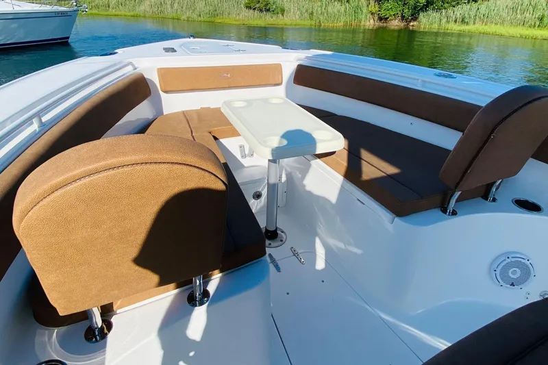 Slide: The Image of 2021 Sea Hunt Ultra 265 SE boat interior with brown seating and table. - 22