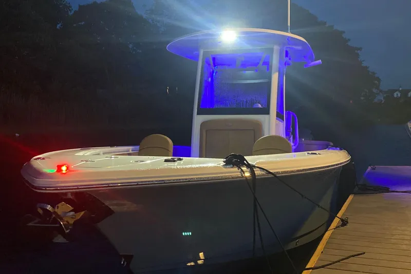Slide: The Image of 2021 Sea Hunt Ultra 265 SE boat docked at night with blue lighting. - 29
