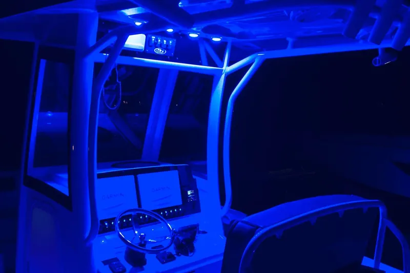 Slide: The Image of 2021 Sea Hunt Ultra 265 SE boat interior with blue LED lighting at night. - 31