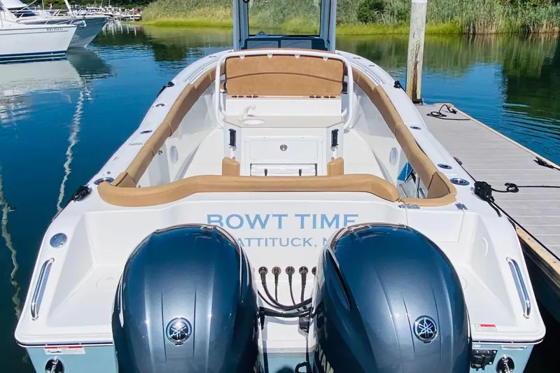 Slide: The Image of 2021 Sea Hunt Ultra 265 SE boat docked with dual engines, featuring tan seating. - 6